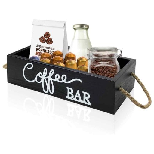 Photo of a black coffee bar organizer with white lettering saying coffee bar and milk, coffee beans and Nespresso pods inside.