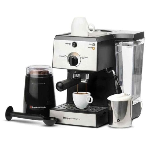 Photo of a silver EspressoWorks Espresso Machine with a grinder by its side and taking a cup of espresso coffee.