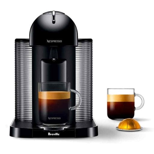 Photo of a black Nespresso Vertuo Espresso Machine with a cup of espresso coffee and a nespresso pod by its side.